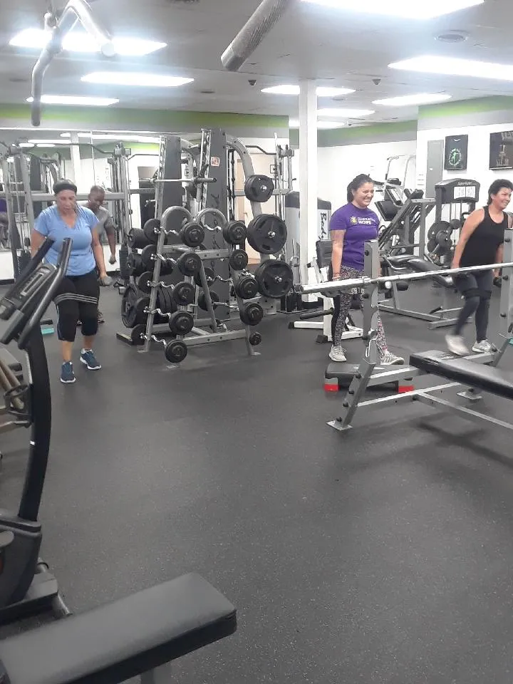 A small group session on the gym floor with the rack and benches behind