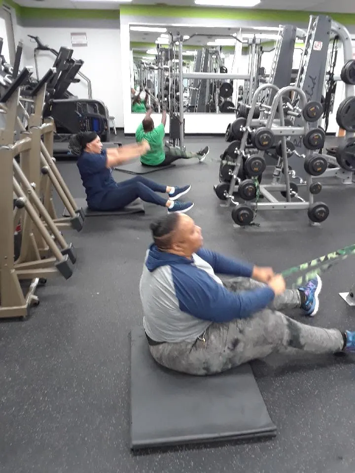 Members doing seated band rows on mats during a small group session at Year 20Fit